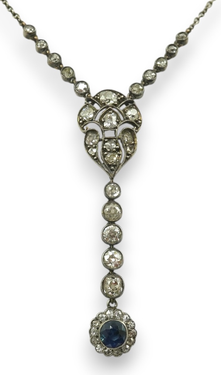 A Belle Epoque gold and silver, millegrain set sapphire and diamond cluster set drop pendant necklace